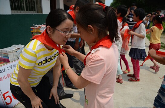 捐贈儀式上，孩子們?yōu)閻坌奶焓瓜瞪霞t領巾