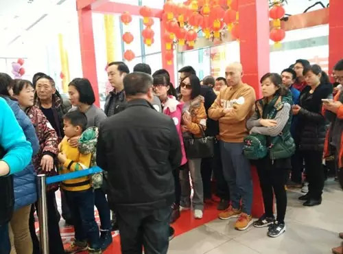 排隊(duì)領(lǐng)年貨，一家老小齊上陣。
