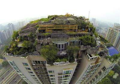 　　昨日，身穿橘黃色馬甲的工作人員在人濟(jì)山莊樓頂拆除違章建筑。新京報(bào)記者 吳江 攝