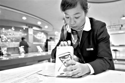 11月6日，北京移動西直門營業(yè)廳的工作人員在為顧客購買的4G手機(jī)登記。新華社發(fā)