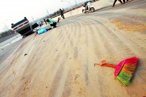 被撞的環(huán)衛(wèi)工躺在地上，身上蓋著藍(lán)色布?jí)K，現(xiàn)場(chǎng)除散落的汽車(chē)碎片外，還留有被撞斷的掃帚。