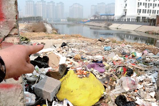 金水河長江路橋下河水發(fā)臭，水邊堆放眾多垃圾