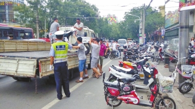 路旁的非機(jī)動(dòng)車道已被多輛違法停放的電動(dòng)車和自行車占滿