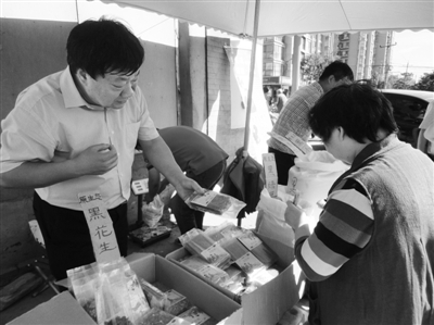 昨日，河南企業(yè)家劉春喜在京“練攤”，為顧客挑選綠豆。新京報(bào)記者 張玉學(xué) 攝