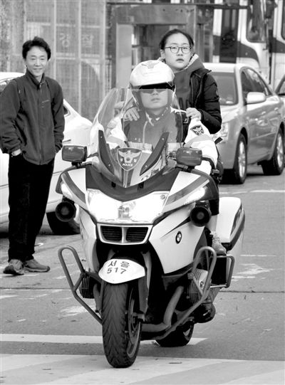 7日，首爾，警察將一名考生送抵考場。新華社發(fā)