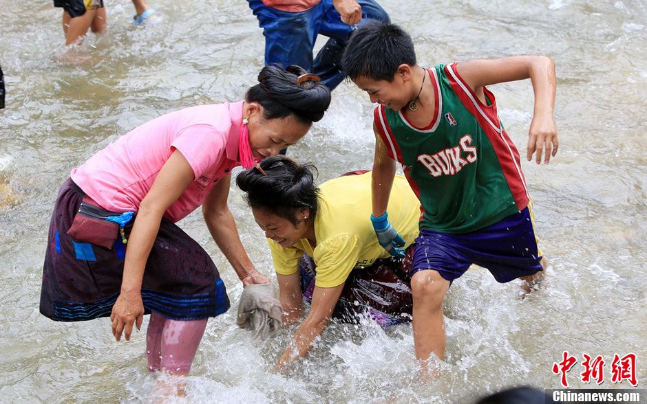 7月9日，村民在小河里摸魚搶魚。譚凱興 攝