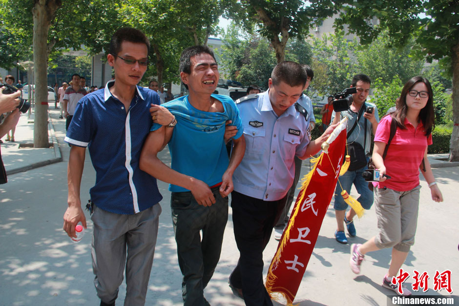 圖為獲救嬰兒父親情緒一度失控，當(dāng)?shù)鼐焦ぷ魅藛T對其進行攙扶。張一辰 攝