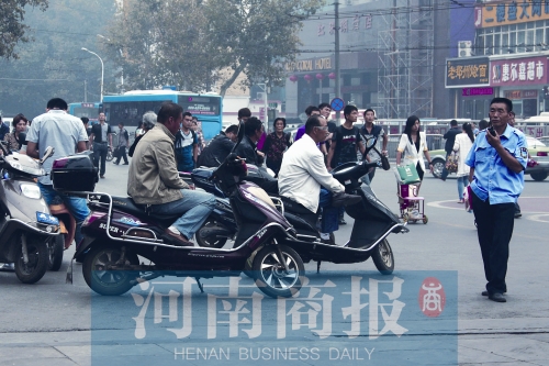 　火車站廣場北側(cè)，幾輛摩的正在等客