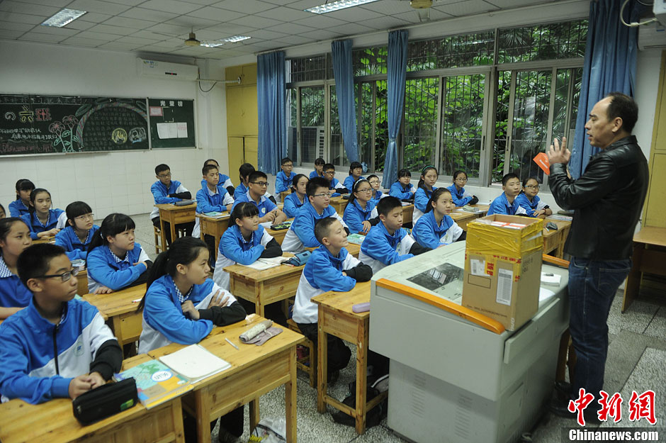 圖為老師正在向同學(xué)們講解用非智能手機對他們的好處。