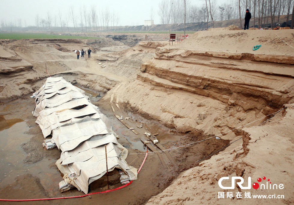 2014年1月6日，河南洛陽古沉船發(fā)掘現(xiàn)場，近日有雨雪天，考古人員給古沉船披上一層“雨衣”。