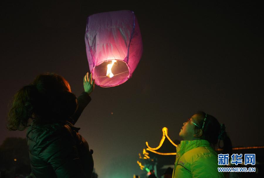 　1月30日，游客在江蘇省鎮(zhèn)江市金山公園門口放飛孔明燈。