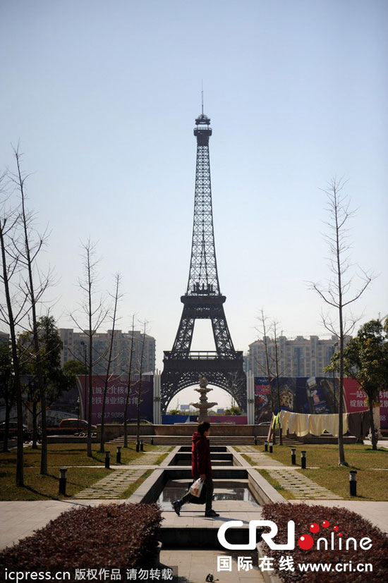 　2014年3月21日，杭州天都城，農(nóng)民在山寨埃菲爾鐵塔下耕作。圖片來(lái)源：東方IC