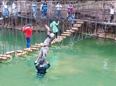 中年男游客正踩著景區(qū)安全員郭小明的肩膀過河。網(wǎng)友“@我的小名叫張孩”供圖