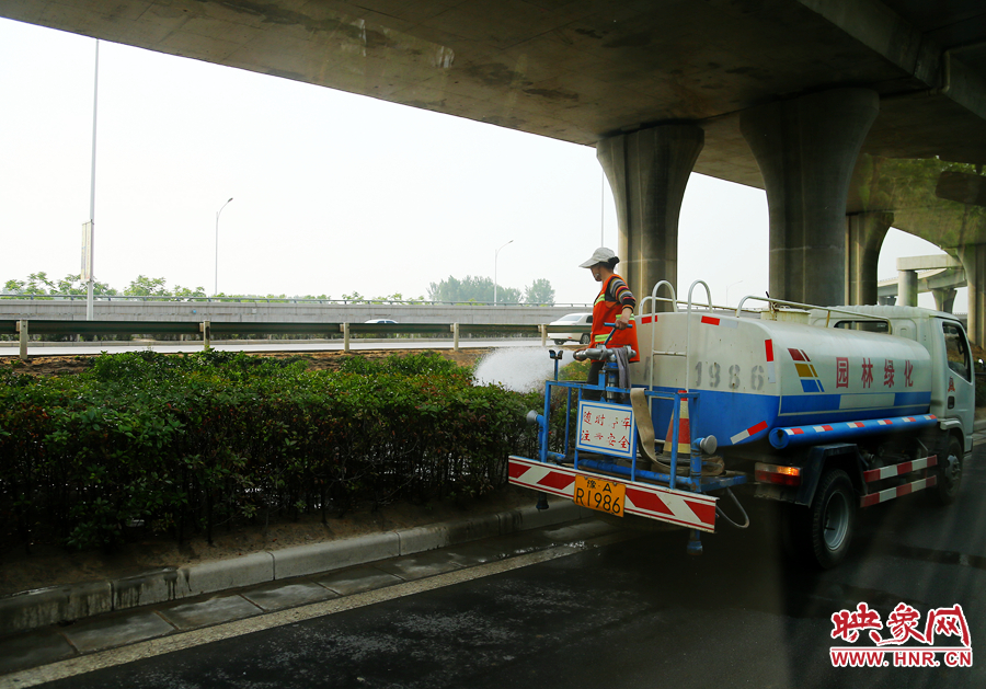 環(huán)衛(wèi)工人對綠化帶進(jìn)行養(yǎng)護(hù)