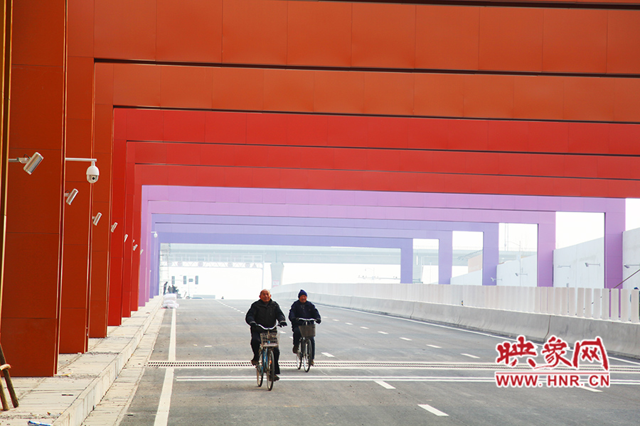 兩位老人騎自行車(chē)通過(guò)。