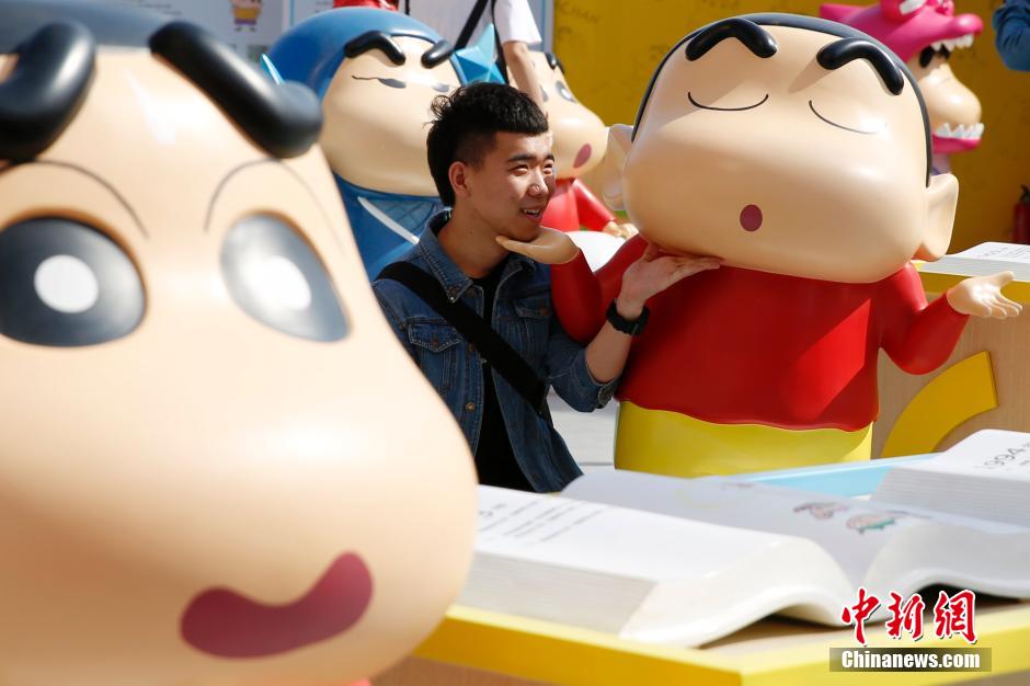 4月22日，游客與蠟筆小新合影。“蠟筆小新25周年紀(jì)念特展”日前在北京開展，吸引了不少市民游客。