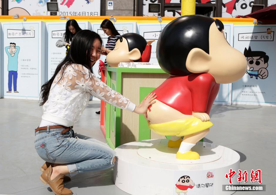 4月22日，游客與蠟筆小新合影?！跋灩P小新25周年紀(jì)念特展”日前在北京開展，吸引了不少市民游客。