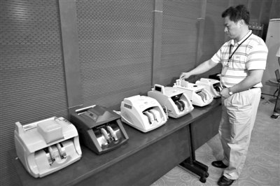 昨日，央行工作人員用各種驗(yàn)鈔機(jī)對(duì)C1F9假幣進(jìn)行測(cè)試，機(jī)器均能及時(shí)作出異常報(bào)警反應(yīng)。新京報(bào)記者 浦