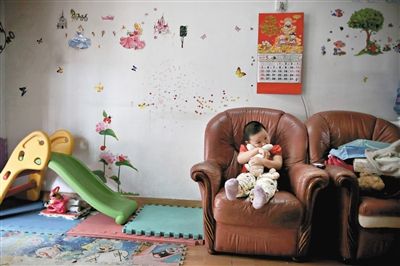 6月14日，未婚媽媽于軍的家里。女兒悅悅抱著兔子玩偶，在聽(tīng)媽媽手機(jī)上的兒歌，這個(gè)4歲女孩喜歡兔子。