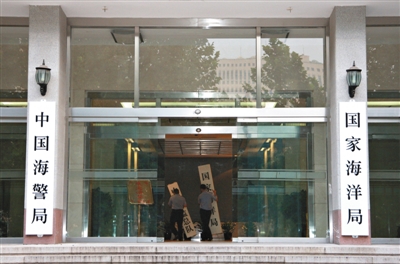 昨日，中國海警局掛牌成立。原國家海洋局和中國海監(jiān)總隊的牌匾被摘下，國家海洋局和中國海警局的新牌匾換上。黃冉 攝