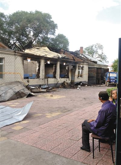 7月27日，海倫聯(lián)合敬老院內(nèi)，幾名老人看著對(duì)面被燒毀的特護(hù)病房。新京報(bào)記者 涂重航 攝