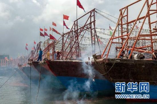 2013年8月1日 南海開漁日 臨高迎新港 8月1日，海南省臨高縣漁民在船上鳴放鞭炮慶祝武蓮港開港。