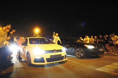 8月24日晚，東壩中街飆車現(xiàn)場(chǎng)，兩輛車并排等待出發(fā)指令，旁邊許多愛(ài)好者前來(lái)觀看比賽。新京報(bào)記者