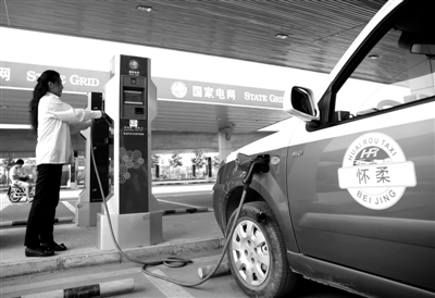 9月11日，懷柔區(qū)，電動(dòng)出租車司機(jī)正在為車輛充電。