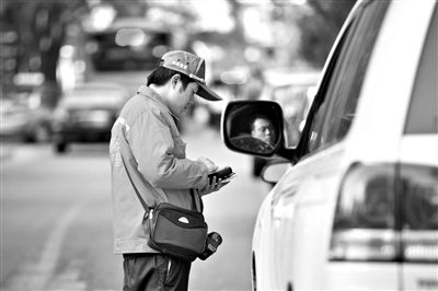 10月15日，朝陽(yáng)區(qū)東大橋路，停車管理員從腰間掏出一個(gè)專用POS機(jī)，正在錄入停車信息。新京報(bào)記者 周崗峰 攝