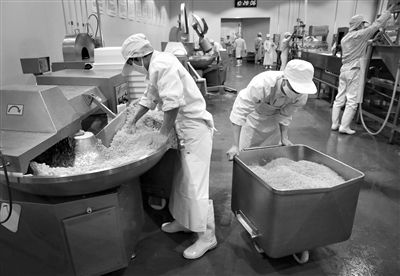 昨日，位于順義李遂開發(fā)區(qū)的慶豐包子鋪配送中心生產(chǎn)車間，工人們正在斬拌胡蘿卜餡料。