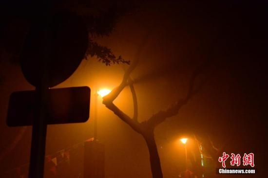 1月31日凌晨，市民行走在煙霧繚繞的南京街頭。當(dāng)天是農(nóng)歷馬年正月初一，南京有限開(kāi)禁燃放煙花爆竹正逢下霧天，空氣的不流通致使煙花爆竹燃燒后產(chǎn)生的顆粒物不能及時(shí)散開(kāi)，造成整座城市煙霧繚繞。據(jù)當(dāng)?shù)丨h(huán)保部門(mén)發(fā)布的信息顯示，空氣質(zhì)量屬重度污染。中新社發(fā) 泱波 攝