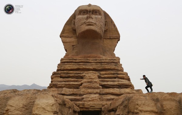 石家莊郊外，一名男子與山寨版獅身人面像合影留念。