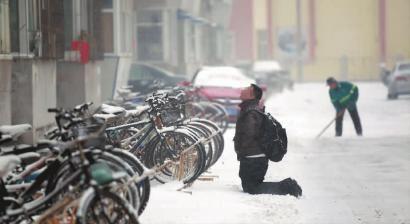 小伙子跪在樓前，一直抬頭看著樓上。 孫立國/攝