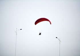 10月25日下午，動力傘從一對路燈上空飛過