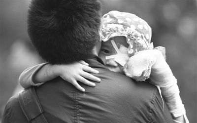 昨日，北京同仁醫(yī)院，被砍傷的彤彤趴在舅舅的肩上。他們剛剛掛完號，正準備回旅館。新京報記者 尹亞飛 攝