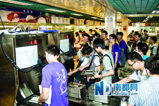 昨日，華南理工大學(xué)一食堂內(nèi)，學(xué)生們正在使用新安裝的自動(dòng)打飯機(jī)打飯。中新社發(fā)