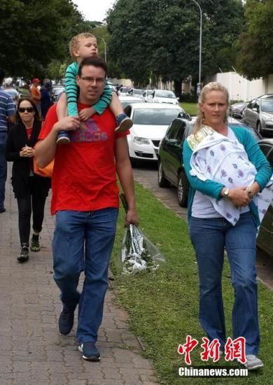圖為一個(gè)白人家庭，由父母帶著孩子到曼德拉家門(mén)外悼念。中新社發(fā) 宋方燦 攝