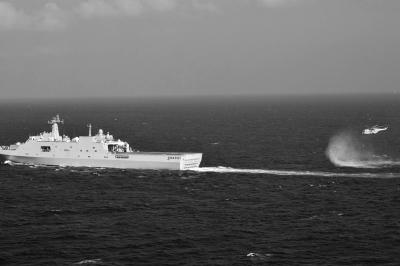 11日，抵達馬航飛機失聯(lián)海區(qū)的海軍井岡山艦與艦載直升機協(xié)同展開立體搜救行動。新華社發(fā)