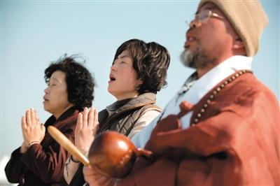 23日，一名僧侶引領(lǐng)人們?yōu)樗勒咂矶\。