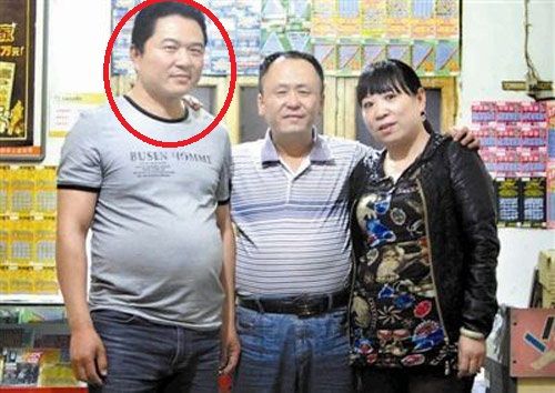 中獎?wù)呲w應(yīng)光(左 腦袋畫了紅圈圈那位大哥)和彩票投注站老板張老二(中)及張老二的妻子合影