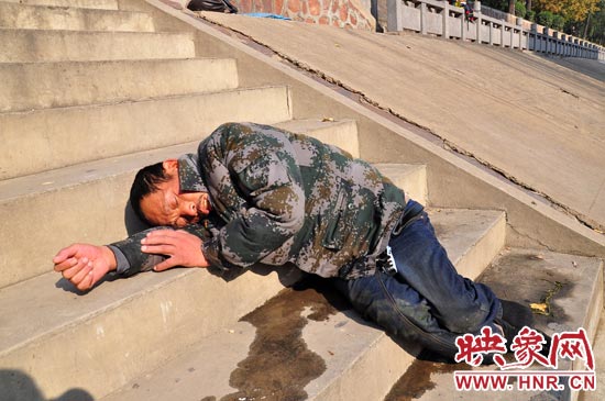 這名男子的衣服以及褲子全濕透了，水從衣褲里流出來，嘴里散發(fā)著濃烈的酒氣。