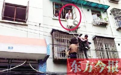 施救現(xiàn)場，劉鵬（圈內(nèi)）先用繩子捆住老太確保安全 勞動報記者 郭娜 供圖