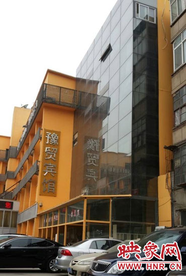 該酒店為加蓋樓層統(tǒng)一安裝上黑色玻璃，從前面看不出加蓋的痕跡