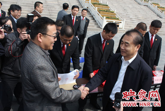 在新密市法院，省高院院長張立勇為拍得轎車的陳先生發(fā)放車鑰匙。