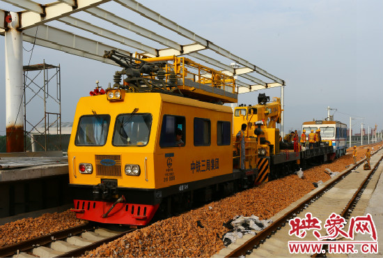 一列工程車從站臺駛過。