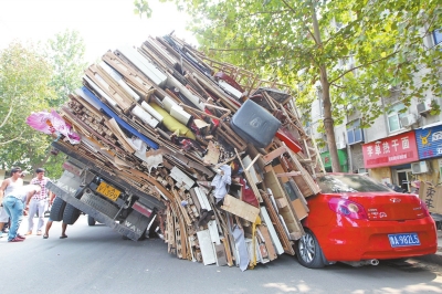 紅色小轎車被砸，卡在路邊動彈不得。