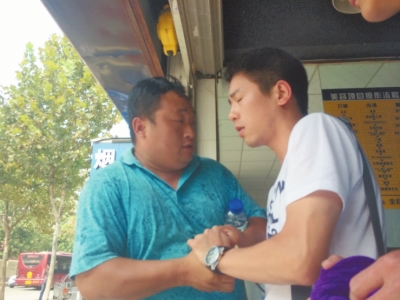 記者正查看照片，突遭藍(lán)衣男強(qiáng)搶手機(jī)。