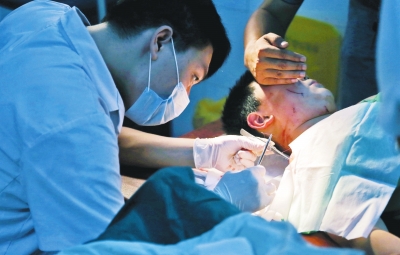 孩子身上有7道傷痕，其中兩道需要縫合，其他的均為擦傷，醫(yī)生正對(duì)他施治。