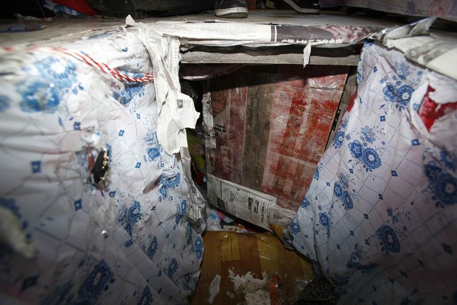 陳小龍?jiān)诔鲎馕萃?，自行又圍起一堵圍墻，安裝了一個(gè)門。圍墻上都是豎起的鐵釘，外面堆著土，鄰居猜是從地底挖出來的。洞口就在床邊，0.5米見方，深約1.5米。洞口表面一塊紙板掩蓋，打開紙板跳入洞底，是一扇小木門，木門外有插銷，可以從外面鎖上。