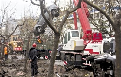 輸油管道爆炸后，搶修人員將被炸毀的車輛運出現(xiàn)場。